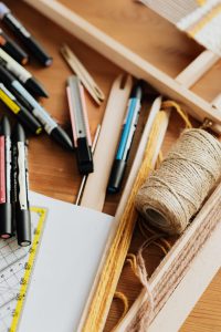 Assorted stationery scattered in wooden drawer