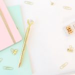 Golden pen notepads and keyboard on white background